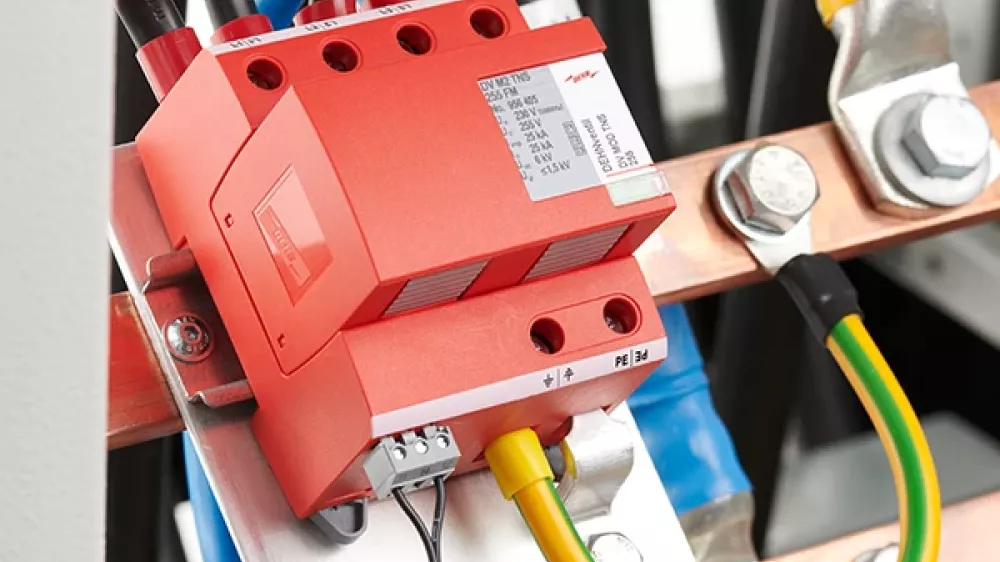 Descargador de sobretensiones rojo, montado y cableado en el armario eléctrico de un cuadro de distribución.