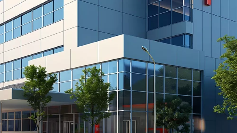 Un hospital con una cruz roja a un lado de la fachada.