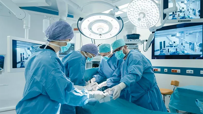 Un grupo de profesionales médicos en un quirófano realizando una operación.