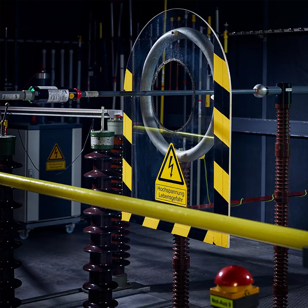Dispositivo de ensayo para avisadores de tensión con rótulo de seguridad negro y amarillo.