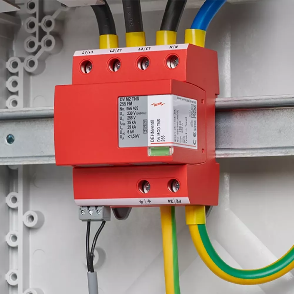 Descargador de sobretensiones rojo, cableado y montado en un carril DIN en el armario eléctrico.