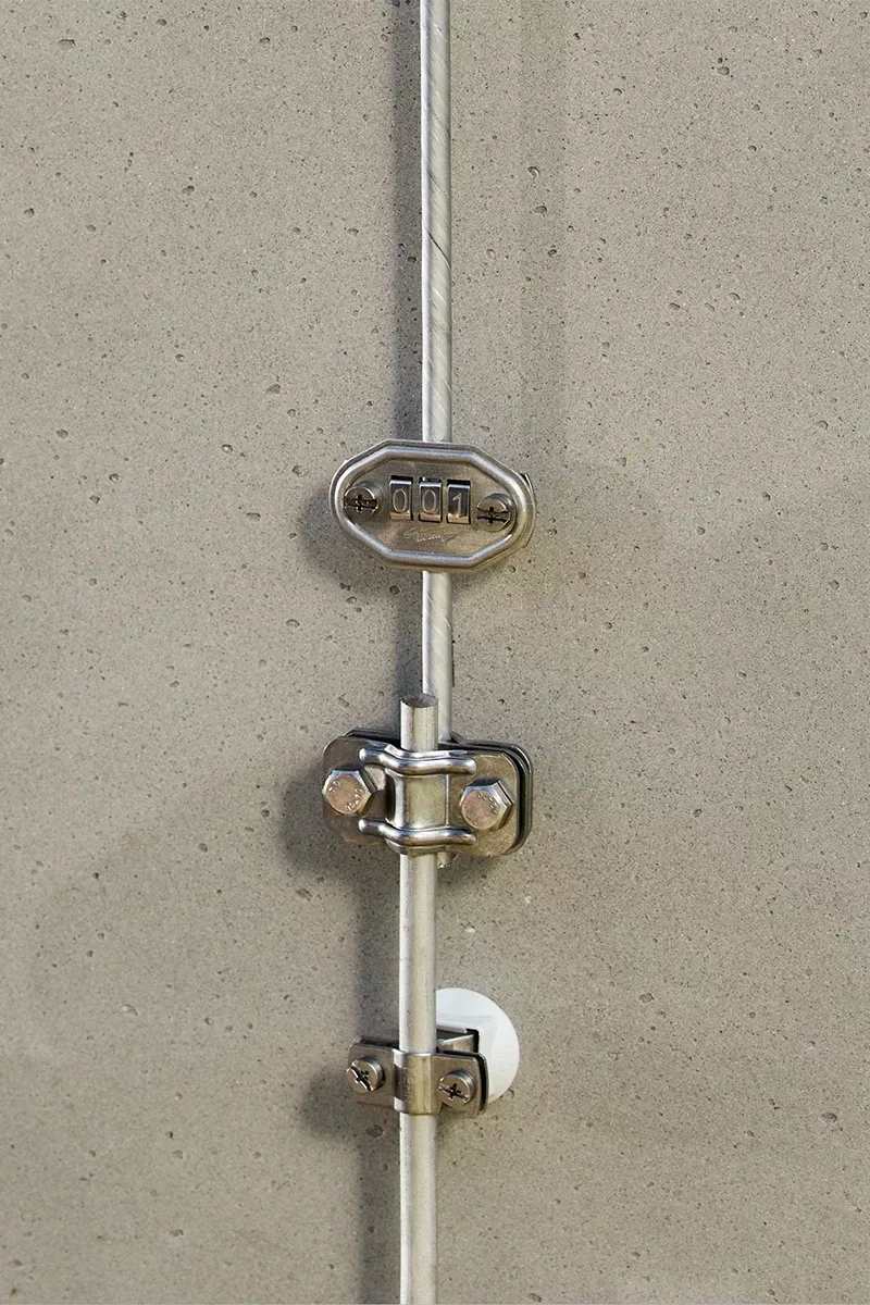 Electrodo de dispersión, formado por conductor redondo y abrazaderas, montado en un muro de hormigón.