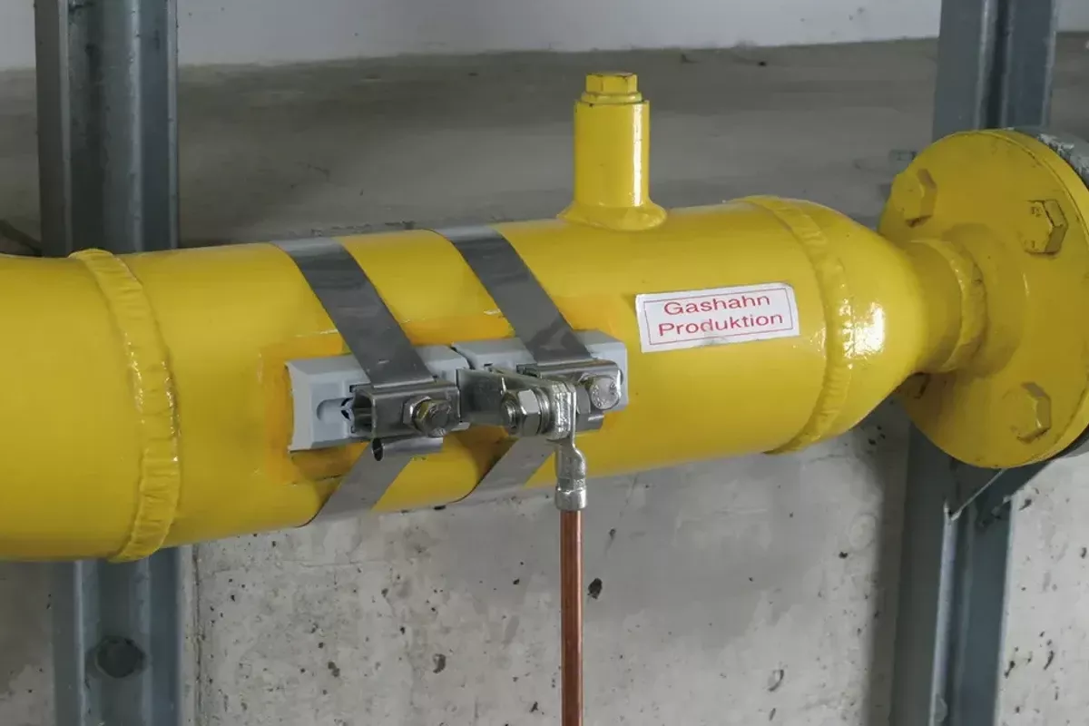 Dos abrazaderas de banda montadas en una tubería de gas amarilla.